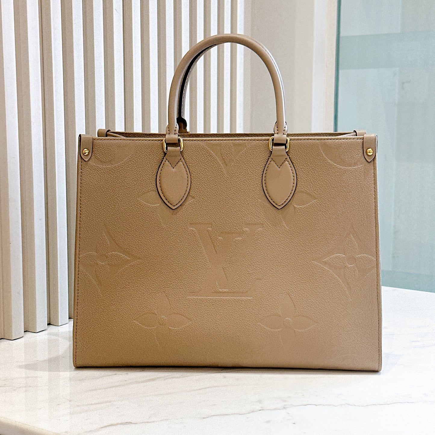 LV On The GO MM in Tourterelle Empreinte Leather