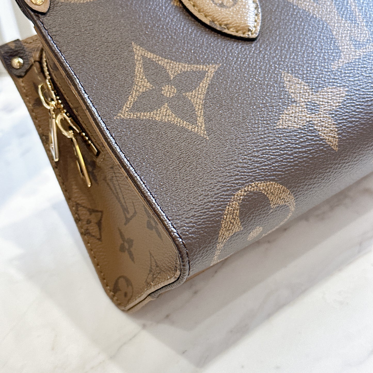 LV On The Go East West Reverse Monogram