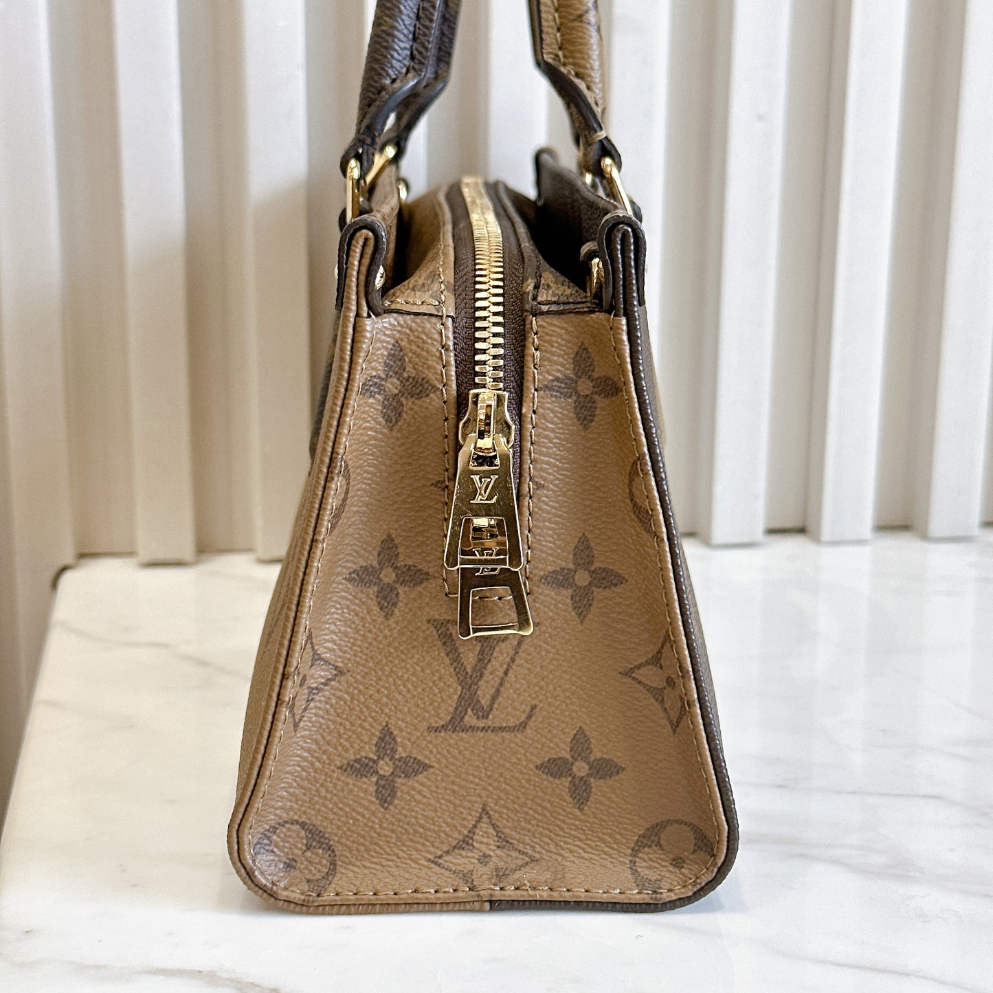 LV On The Go East West Reverse Monogram