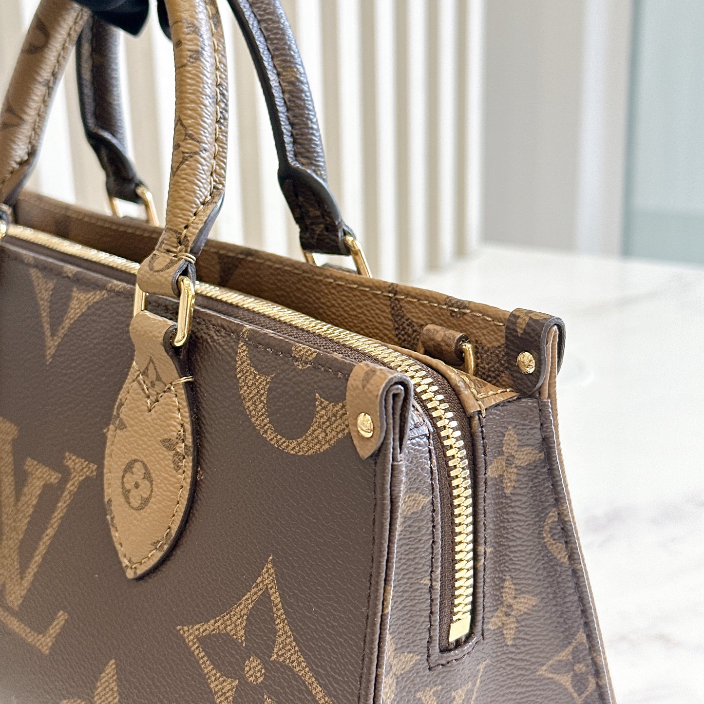 LV On The Go East West Reverse Monogram