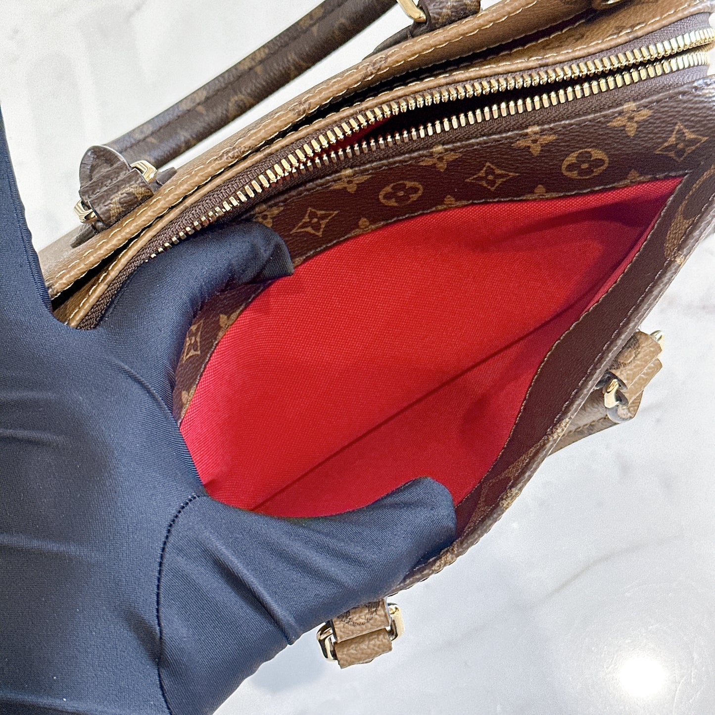 LV On The Go East West Reverse Monogram
