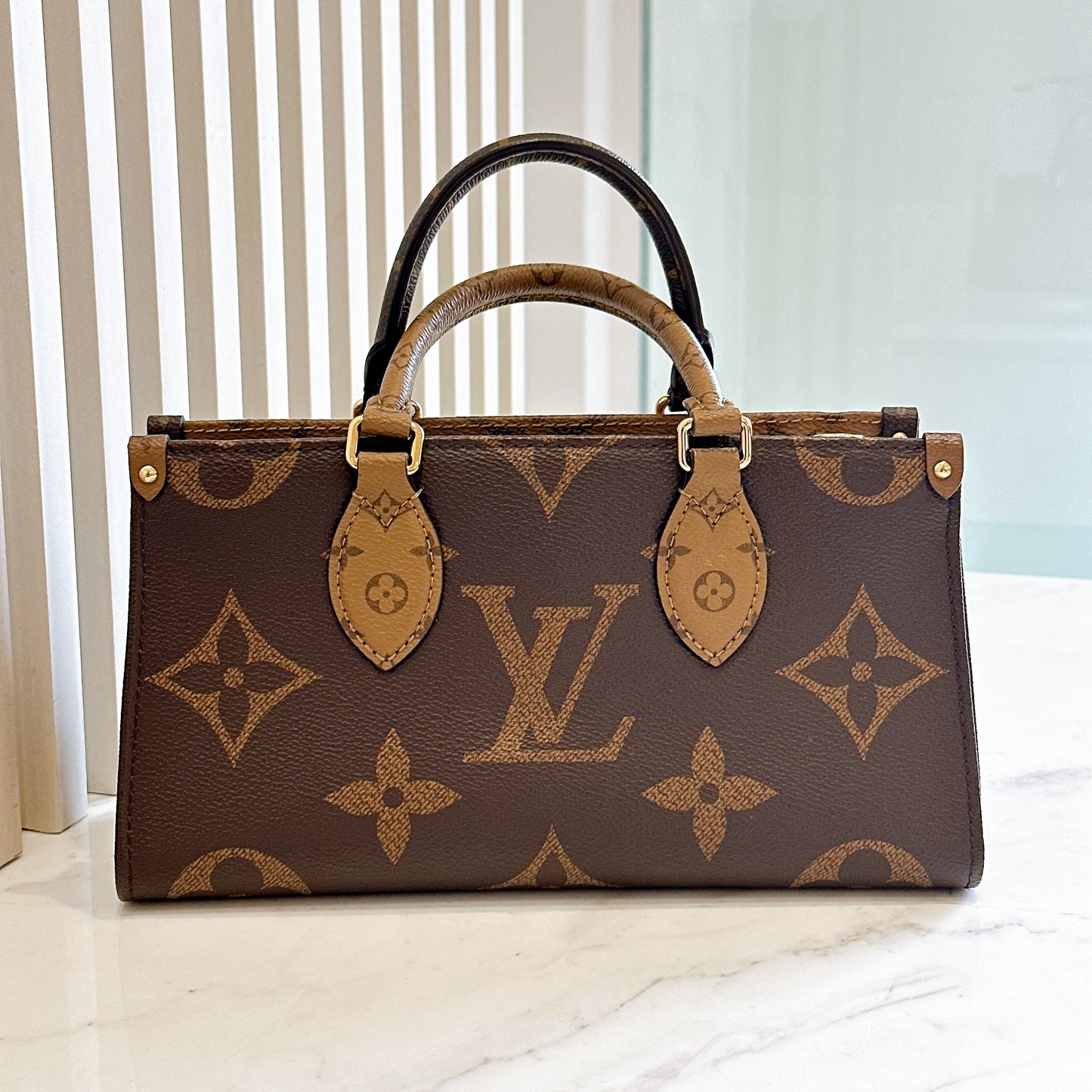 LV On The Go East West in Monogram Reverse