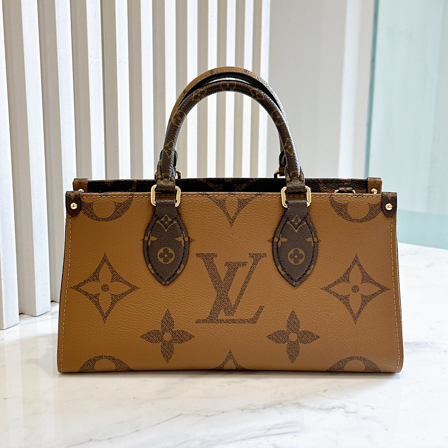 LV On The Go East West in Monogram Reverse