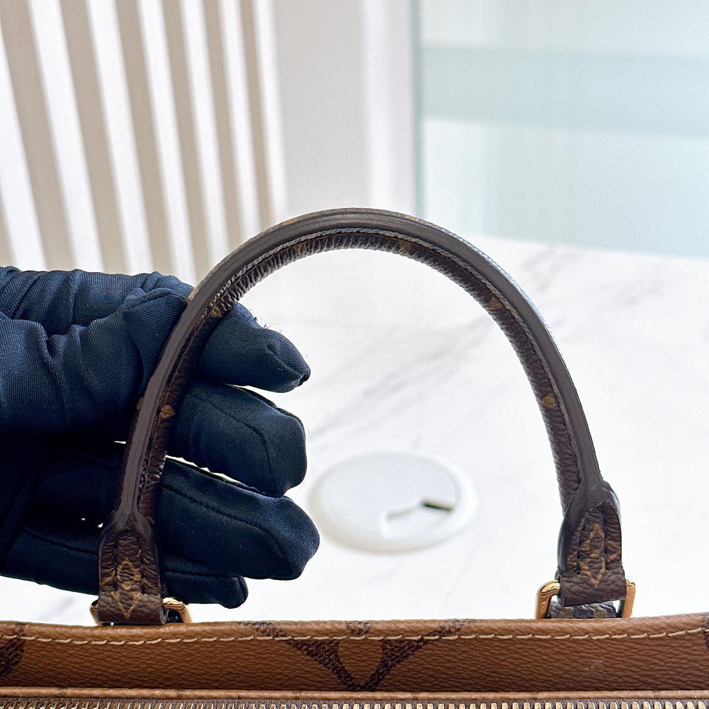 LV On The Go East West in Monogram Reverse