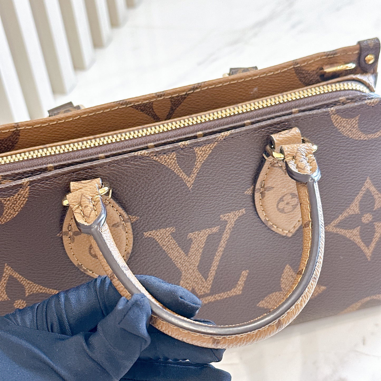 LV On The Go East West in Monogram Reverse