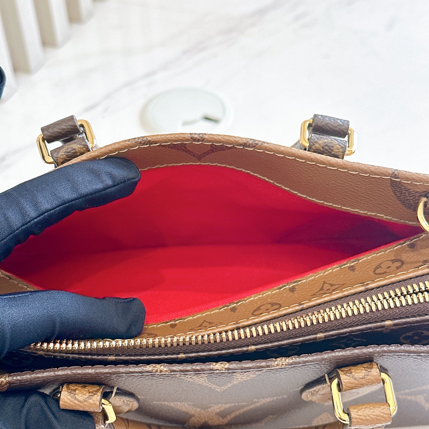 LV On The Go East West in Monogram Reverse