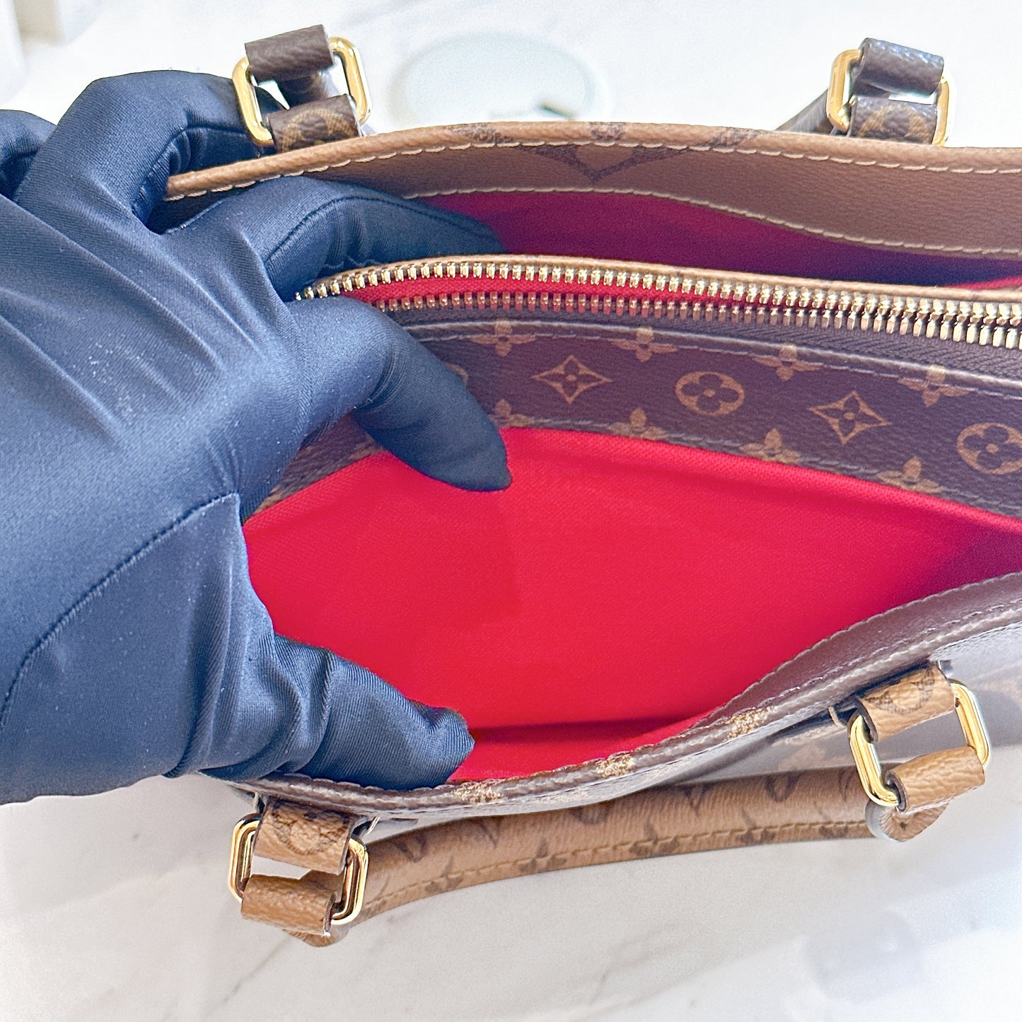 LV On The Go East West in Monogram Reverse